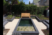 Tuin met vijver en borders van stapelblokken