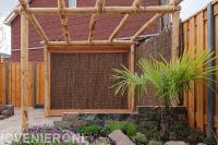 Achtertuin met beton hout schutting en terras