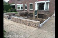 Tuinaanleg met schanskorven en bloembakken van cortenstaal