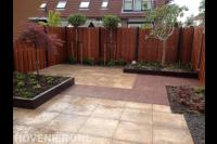 Achtertuin met hardhouten schutting, verhoogde borders en bestrating