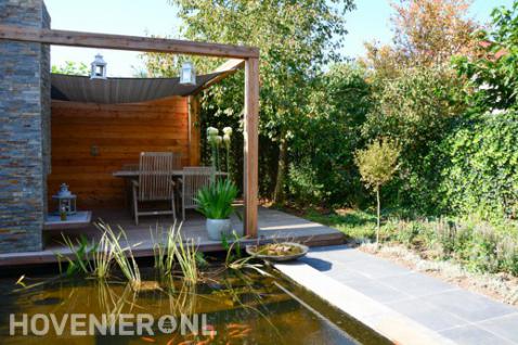 Houten veranda met schaduwdoek en tuinhaard bij vijver 2