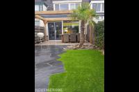 Tuinaanleg met terras, houten pergola, flagstones en gazon