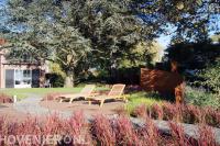 Tuin met kleurrijke beplanting, vlonder en looppad van koppelstenen 2