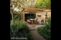 Stevige houten pergola boven terras met houten tuinmeubels