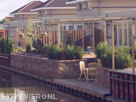 Tuin aan waterkan met vlonder en houten pergola's