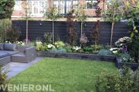Tuinaanleg met terras, gazon, verhoogde borders en leibomen