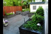 Moderne achtertuin met siertegels en plantenbakken