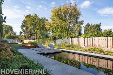 Ruime tuin met grote vijver en kleurrijke beplanting