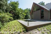 Houten vlonder met buitenverlichting bij vijver