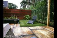 Tuin met houten schutting, gazon en plantenbak