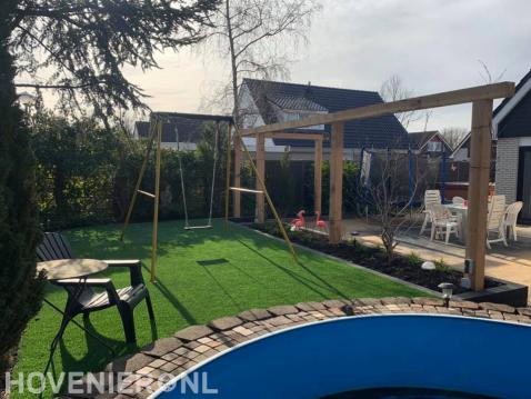 Tuinaanleg met terras, pergola en kunstgras met schommel