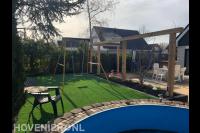 Tuinaanleg met terras, pergola en kunstgras met schommel