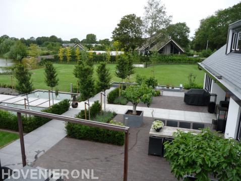 Ruime moderne tuin met strakke vijver en groot gazon en terras 1