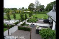 Ruime moderne tuin met strakke vijver en groot gazon en terras 1