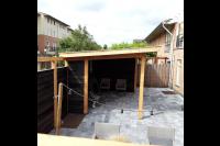 Achtertuin met houten overkapping en nieuwe bestrating