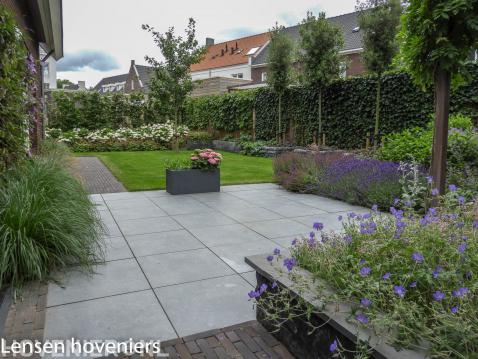 Tuin met terras, gazon en kleurrijke beplanting