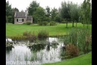 Landelijke tuin met groot gazon en natuurlijke vijver 2