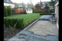 Aanleggen achtertuin met gazon, bestrating en tuinhuis