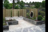 Achtertuin met houten schutting, nieuw straatwerk en verhoogde borders