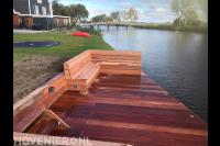 Hardhouten vlonder met houten bankje aan het water