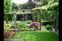 Groene tuin met vijver, pergola en bomen