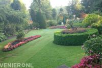 Landelijke tuin met groot gazon en kleurrijke borders