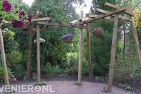 Speelse houten pergola met hangende bloembakken 1
