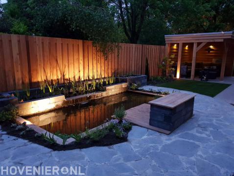 Tuin met vijver en houten overkapping