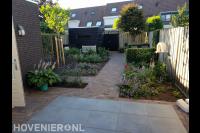 Groene achtertuin met sierbestrating