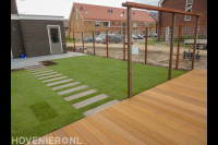 Achtertuin met houten terras en grasmatten
