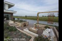 Zitkuil met pergola en vlonder in tuin aan het water