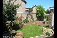 Gezellige achtertuin met gazon en plantenbakken