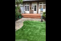 Achtertuin met houten vlonder en kunstgras