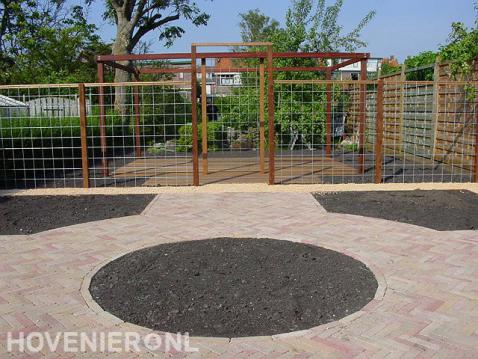 Tuinaanleg met bestrating, vlonder, pergola en schermen van betongaas