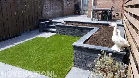 Onderhoudsarme tuin met verhoogd terras, kunstgras en betontegels 3