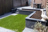 Onderhoudsarme tuin met verhoogd terras, kunstgras en betontegels 3
