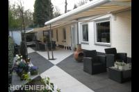 Terras van witte en grijze betontegels met tuinmeubels