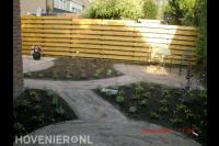 Bestrating van gebakken waaltjes en nieuwe beplanting in achtertuin