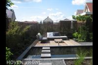 Houten vlonder met loungebanken bij vijver