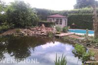 Rotstuin met grote vijver, tuinhuisje en zwembad