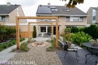 Achtertuin met terras, houten pergola en waterelement