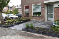 Onderhoudsvriendelijke voortuin met sierbestrating en verhoogde border