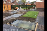 Tuinaanleg met sierbestrating, vijver en gazon van graszoden