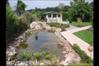 Grote heldere vijver met waterloop en rotsblokken