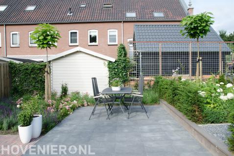 Moderne tuin met veel groen en terras van betontegels 1