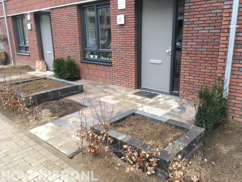 Kleine voortuin met bestrating, bloembakken en beukenhaag