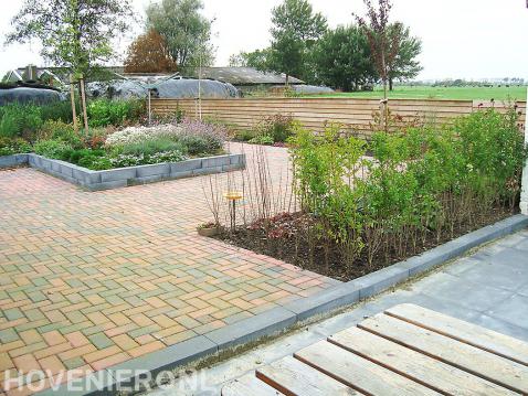 Tuin met bestrating van gekleurde betonklinkers en verhoogde border