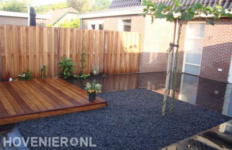 Strakke tuin met houten schutting, vlonder en grote antraciet tegels 2