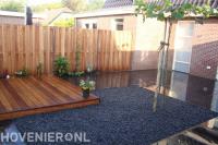 Strakke tuin met houten schutting, vlonder en grote antraciet tegels 2