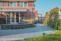 Tuinaanleg met bestrating, pergola, tuinafscheiding en maatwerk bankje